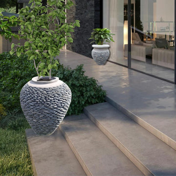 Decorative outdoor planters on a patio with a modern house in the background