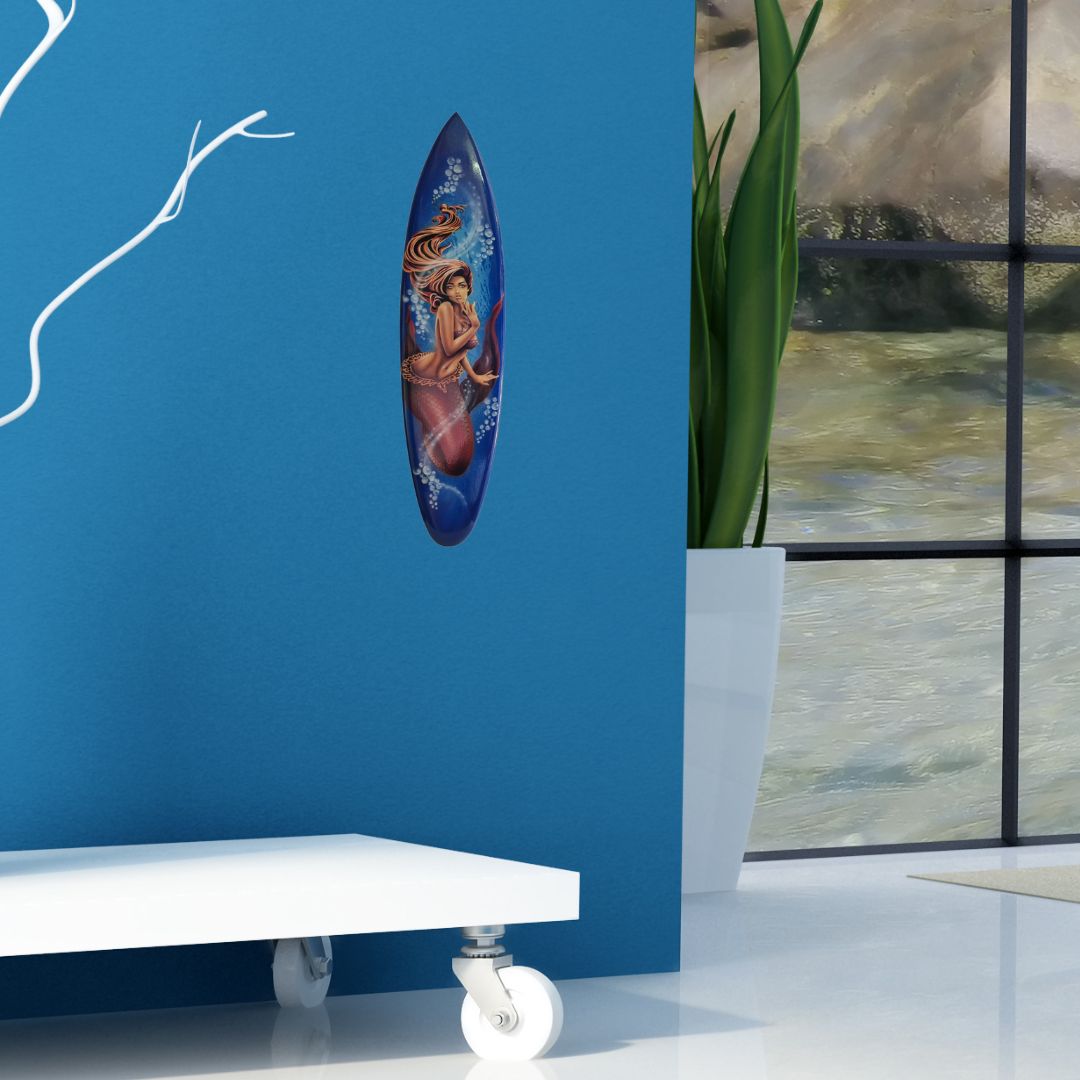 Decorative wall piece on a blue wall with a plant and painting in the background