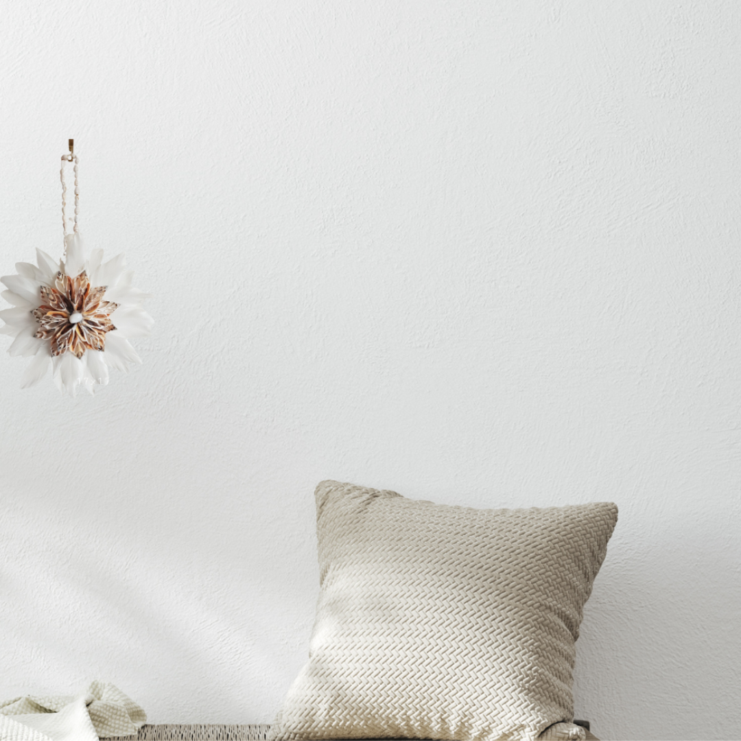 Textured pillow on a white surface with a decorative wall hanging.
