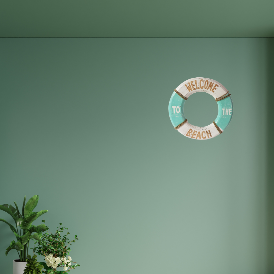 Decorative wall art shaped like a life buoy with 'Welcome to the Beach' text on a green wall.