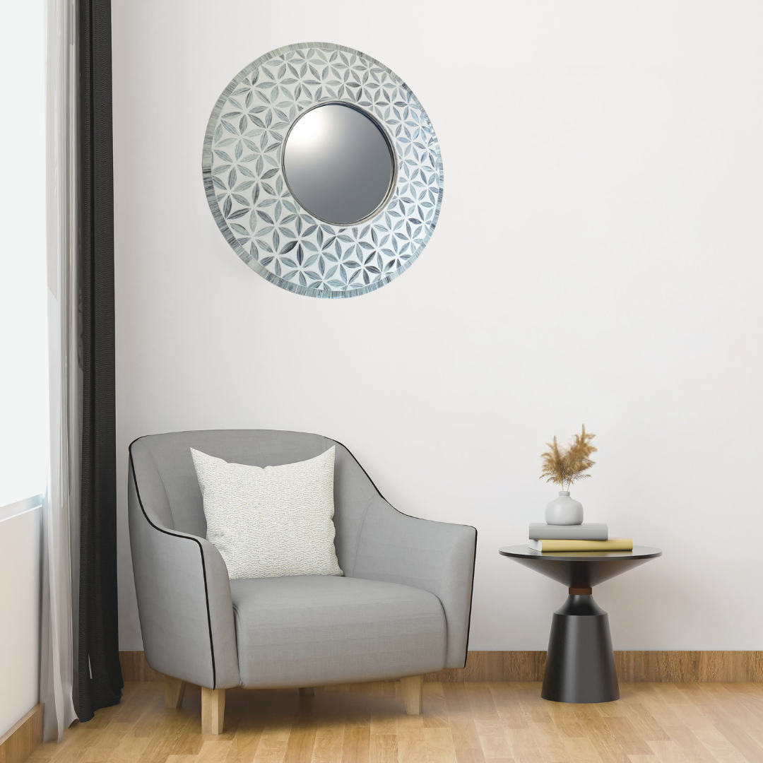 Gray armchair with a decorative mirror and side table in a room.