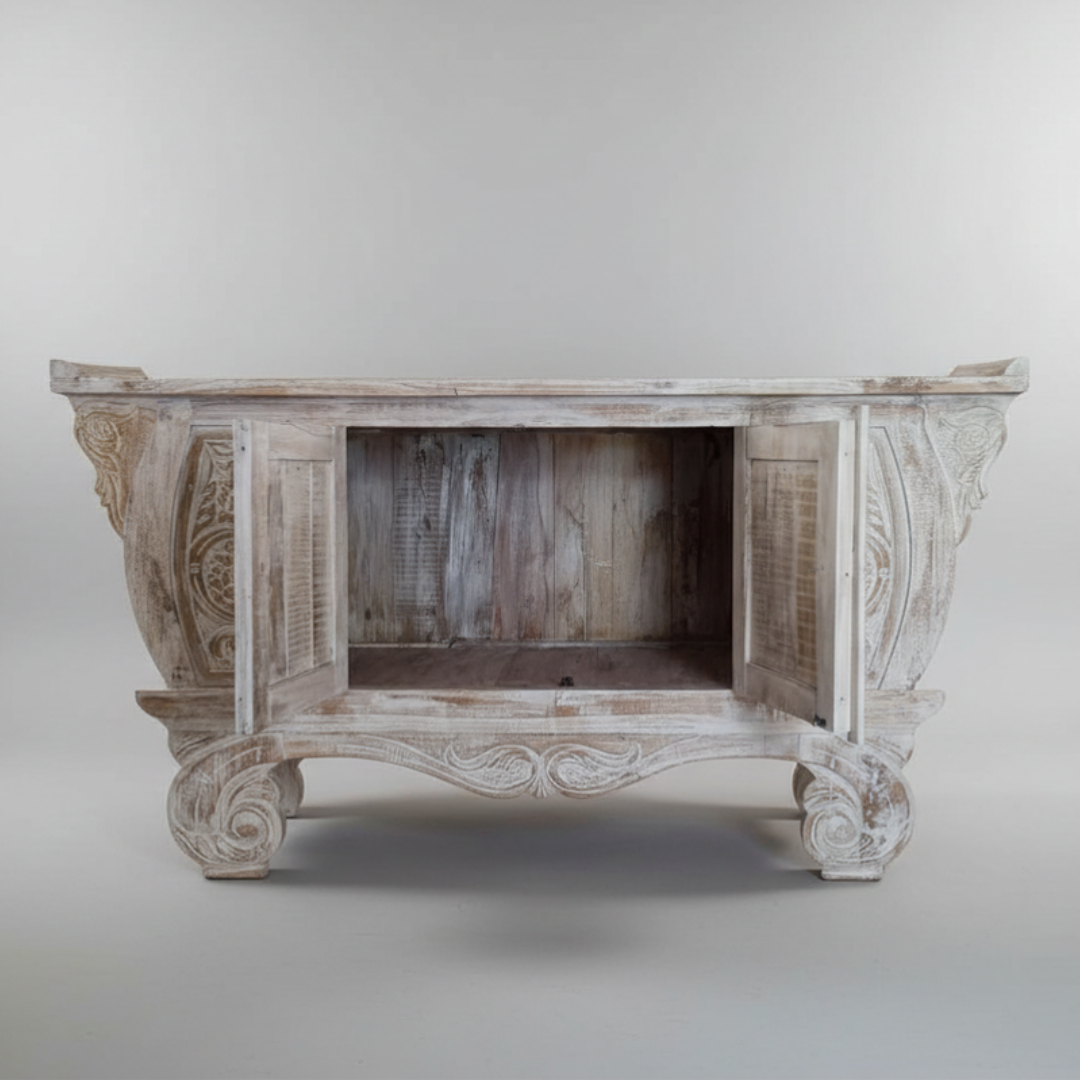 Balinese teak entryway cabinet with doors open showing internal storage space, hand-carved scrollwork detail on grey background