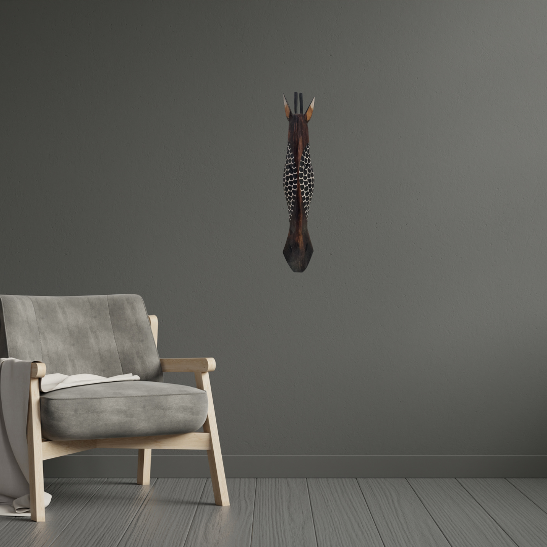 Handcrafted Wooden Giraffe & Zebra Masks Gray armchair in a room with a dark gray wall and a mounted animal head decor.