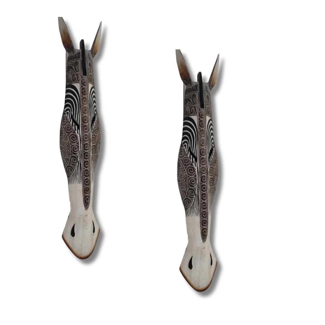 Two decorative wall animal maskith intricate patterns on a white background