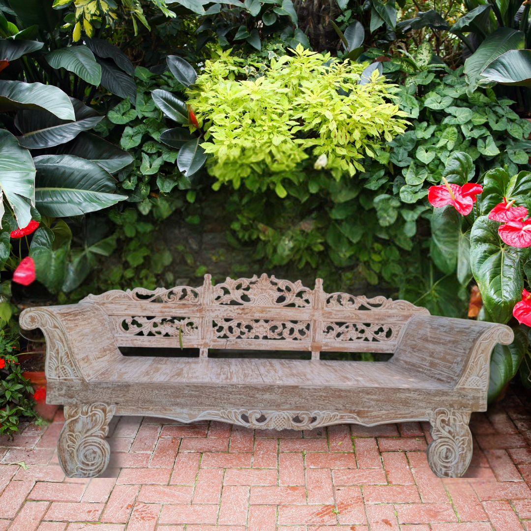 Decorative wooden bench in a garden setting with lush greenery and flowers.