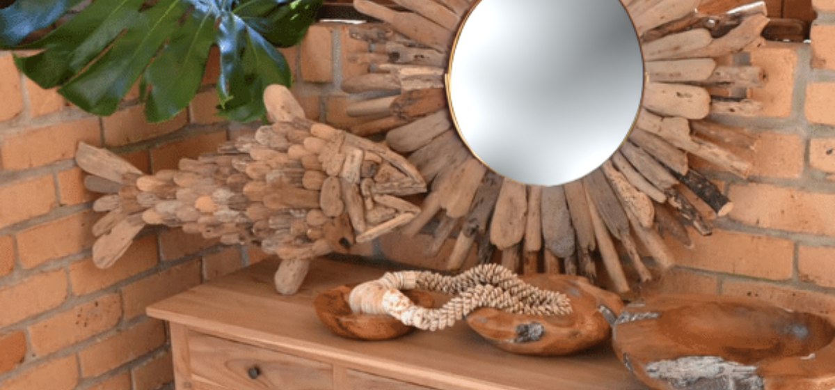 Decorative wooden fish and mirror on a brick wall background