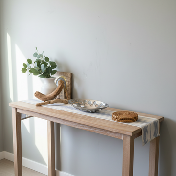 Silver oval cutout bowl styled on coastal hallway console table with eucalyptus and driftwood