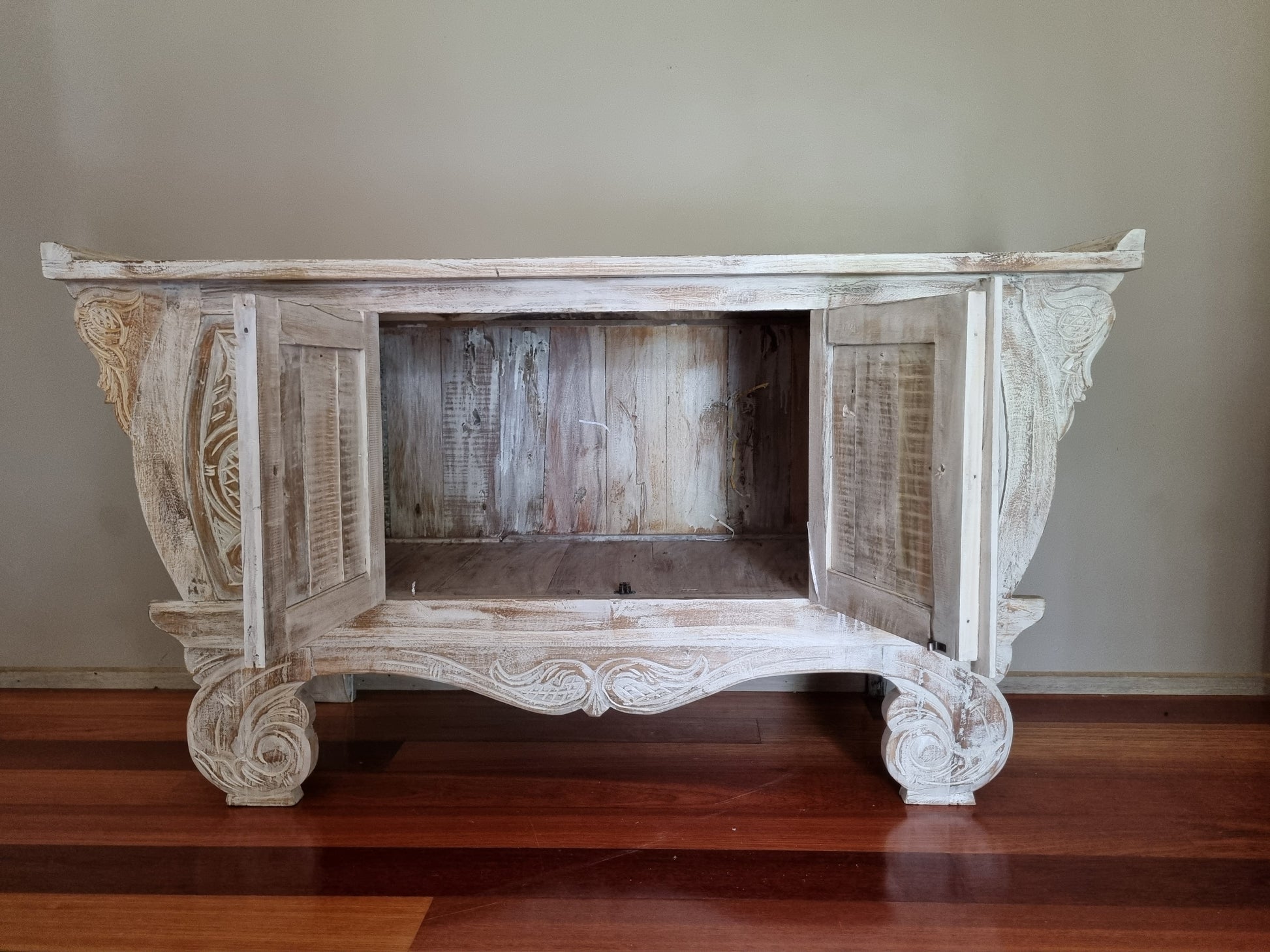 wooden cabinet with doors opened in a dark room 