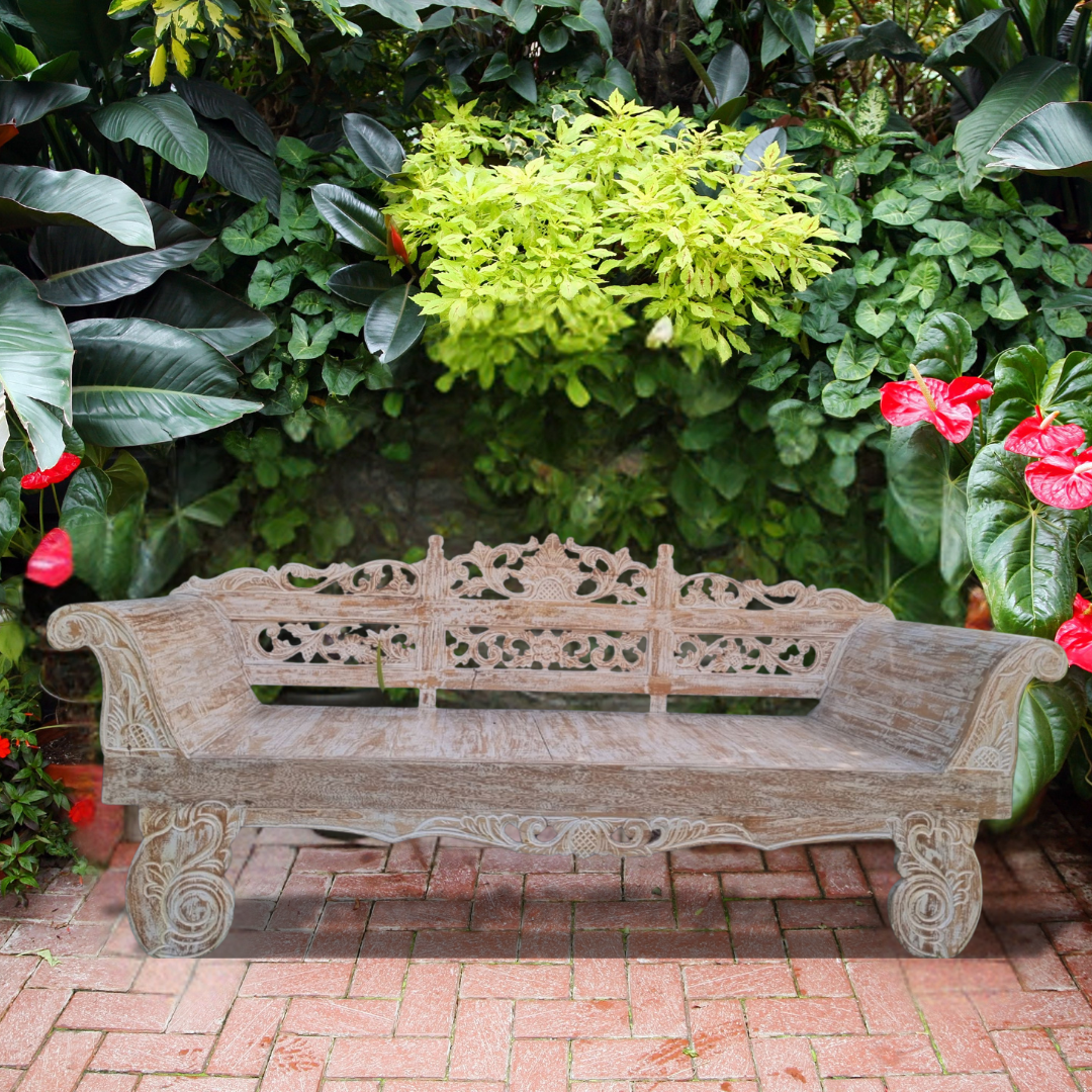 Decorative wooden bench in a garden setting with greenery and flowers.