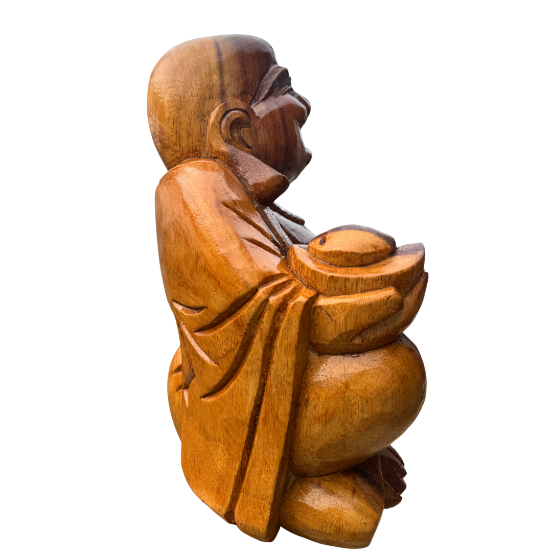 side view of a Wooden statue of a seated figure holding a bowl on a white background