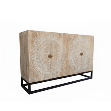 Whitewash teak sideboard angle view, four carved mandala doors with antique brass ring handles, black metal frame base, white background
