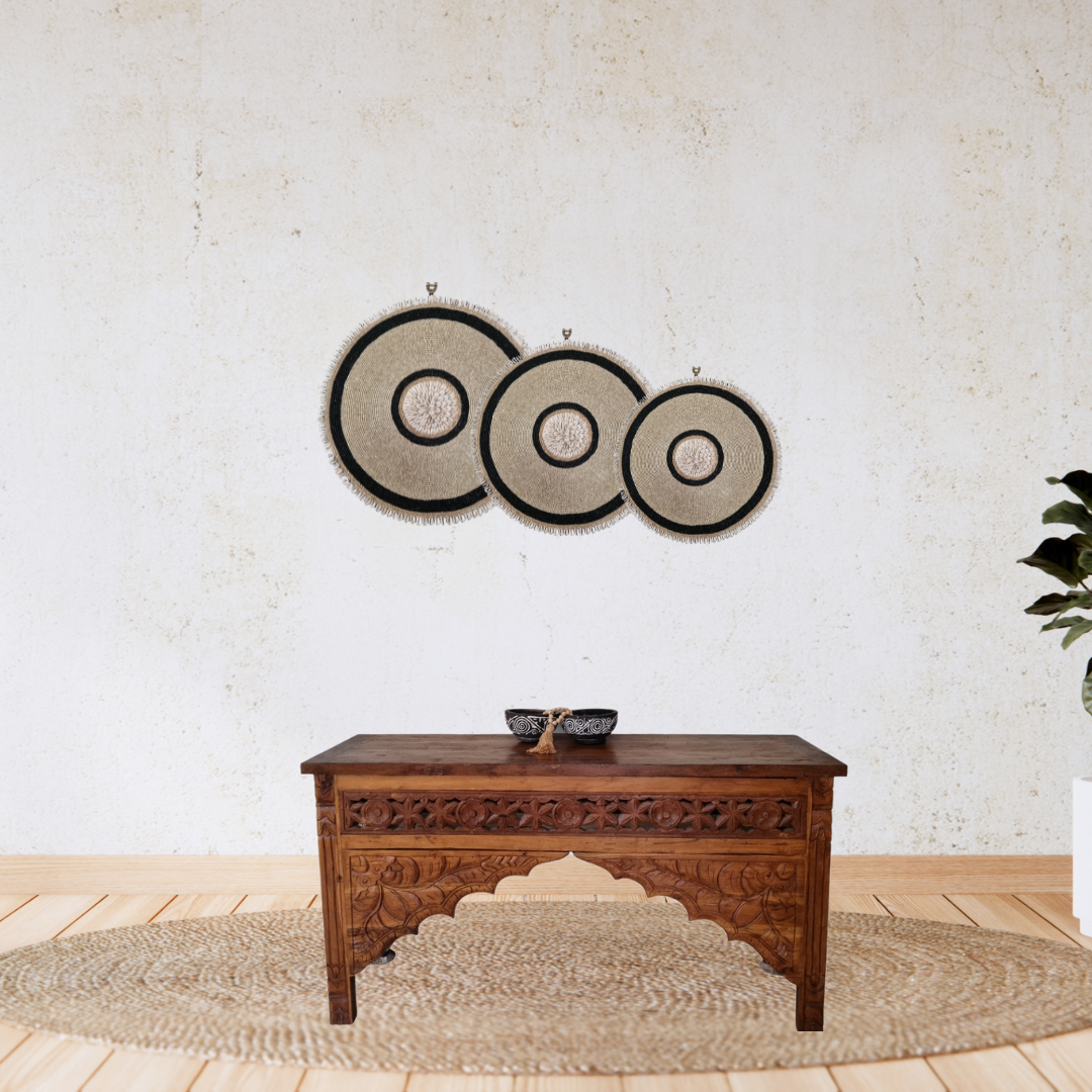 Decorative wall art with circular patterns above a wooden console table.