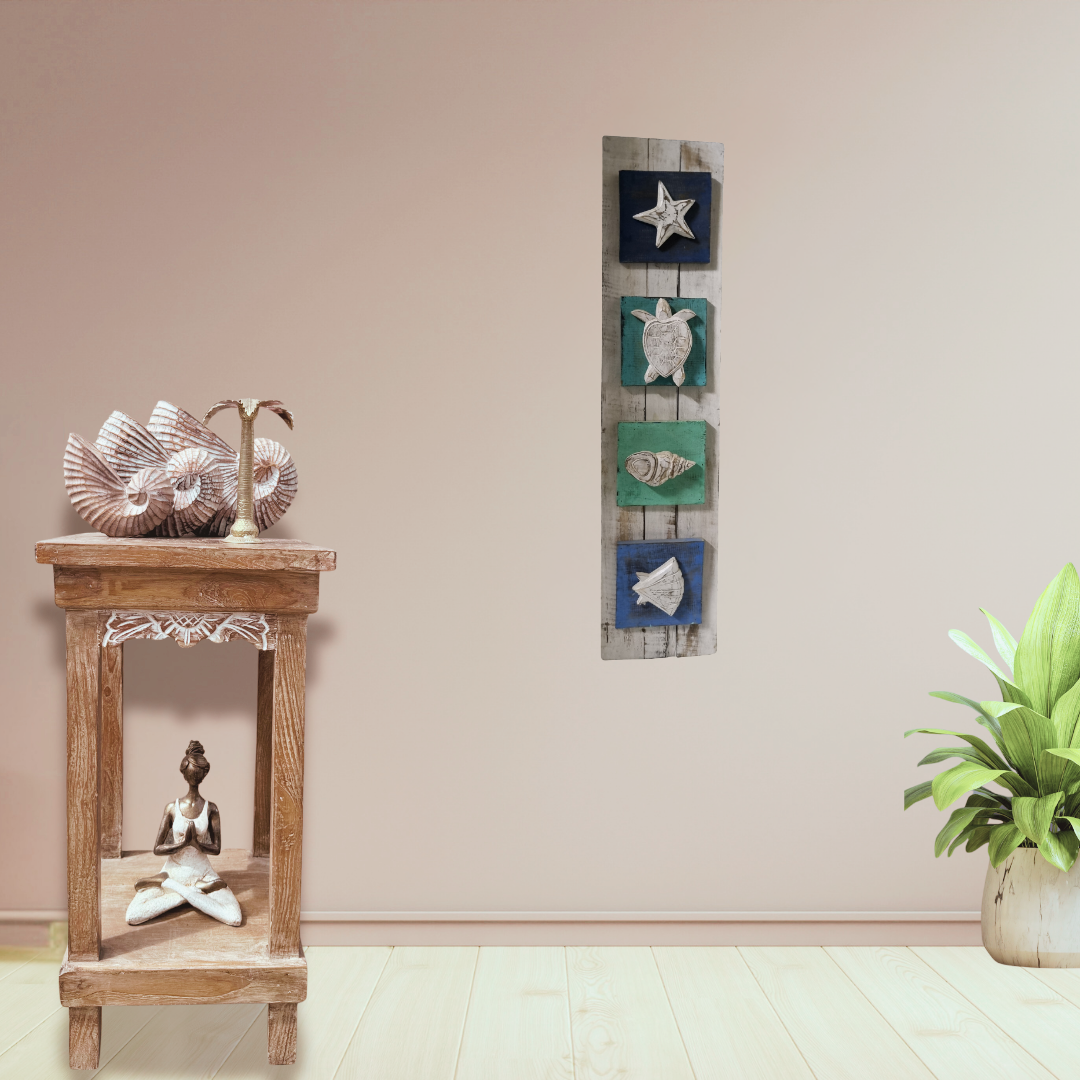 Decorative wall art with sea-themed elements on a beige wall, next to a wooden side table with a sculpture.