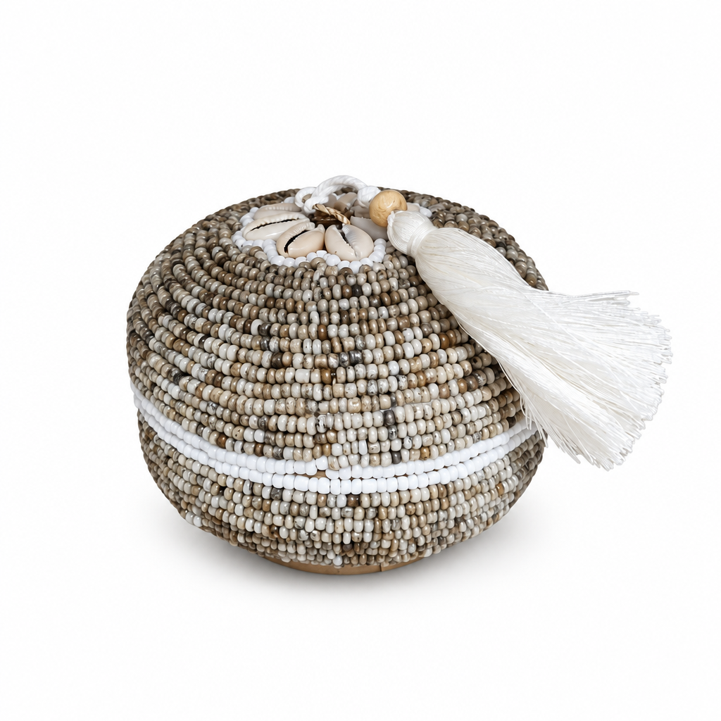 Round beaded piece with cream shell flower detail on a white background

