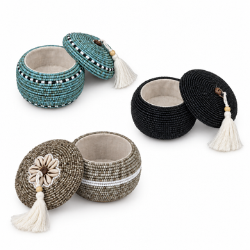 Three scattered beaded trinket boxes opened to show their interiors on a white background