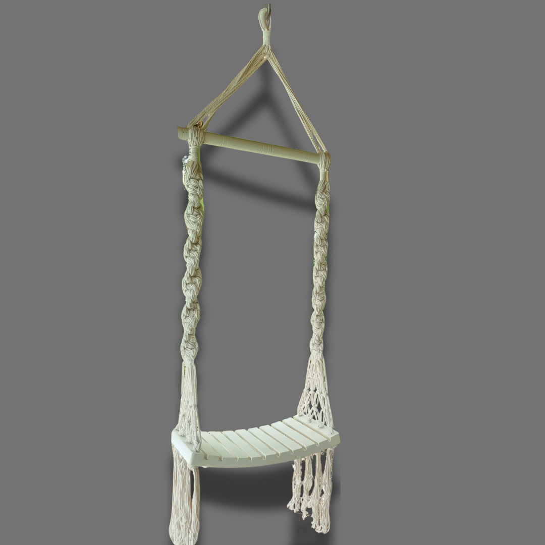 A handcrafted Balinese style white macrame swing with a solid wooden seat, designed with intricate patterns and tassels.