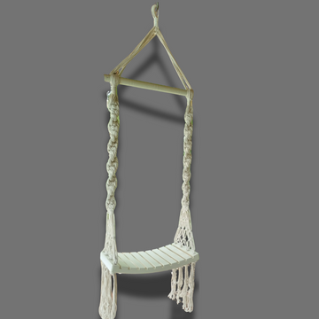 A handcrafted Balinese style white macrame swing with a solid wooden seat, designed with intricate patterns and tassels.