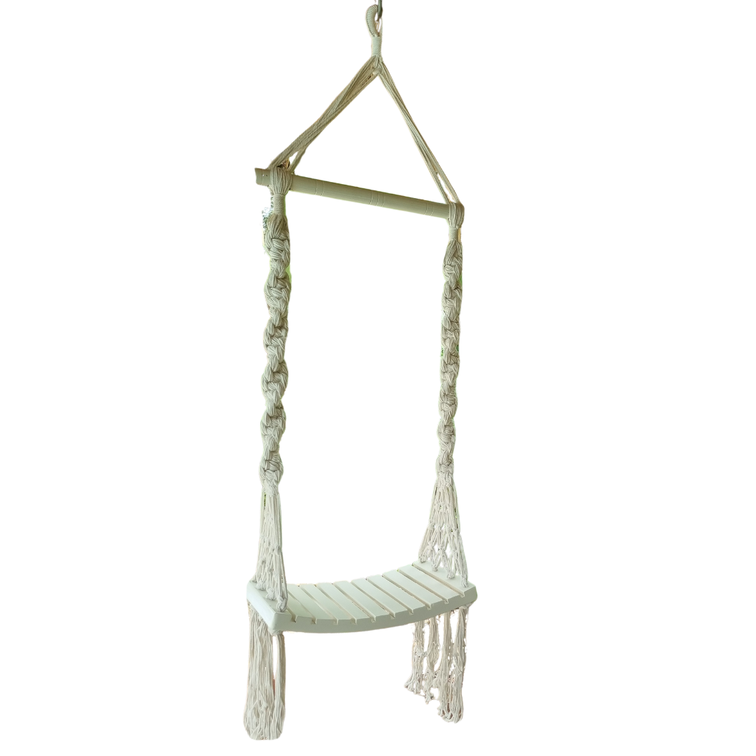 A handcrafted Balinese style white macrame swing with a solid wooden seat, designed with intricate patterns and tassels.