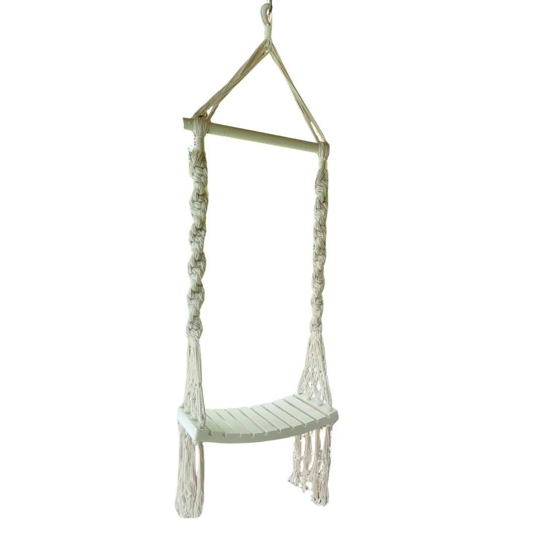 A handcrafted Balinese style white macrame swing with a solid wooden seat, designed with intricate patterns and tassels.