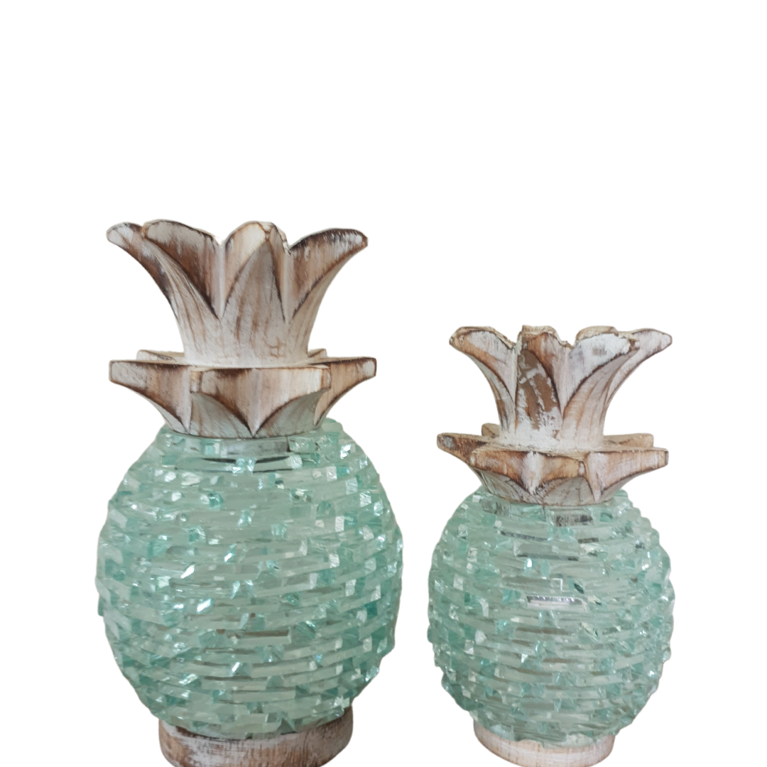 Two sizes of Boho Glass Pineapple Décor side by side — medium and small — showing the aqua sea-glass mosaic textured body and whitewashed carved wooden leaf top in detail, handcrafted tropical boho tabletop sculpture by Azure Decor