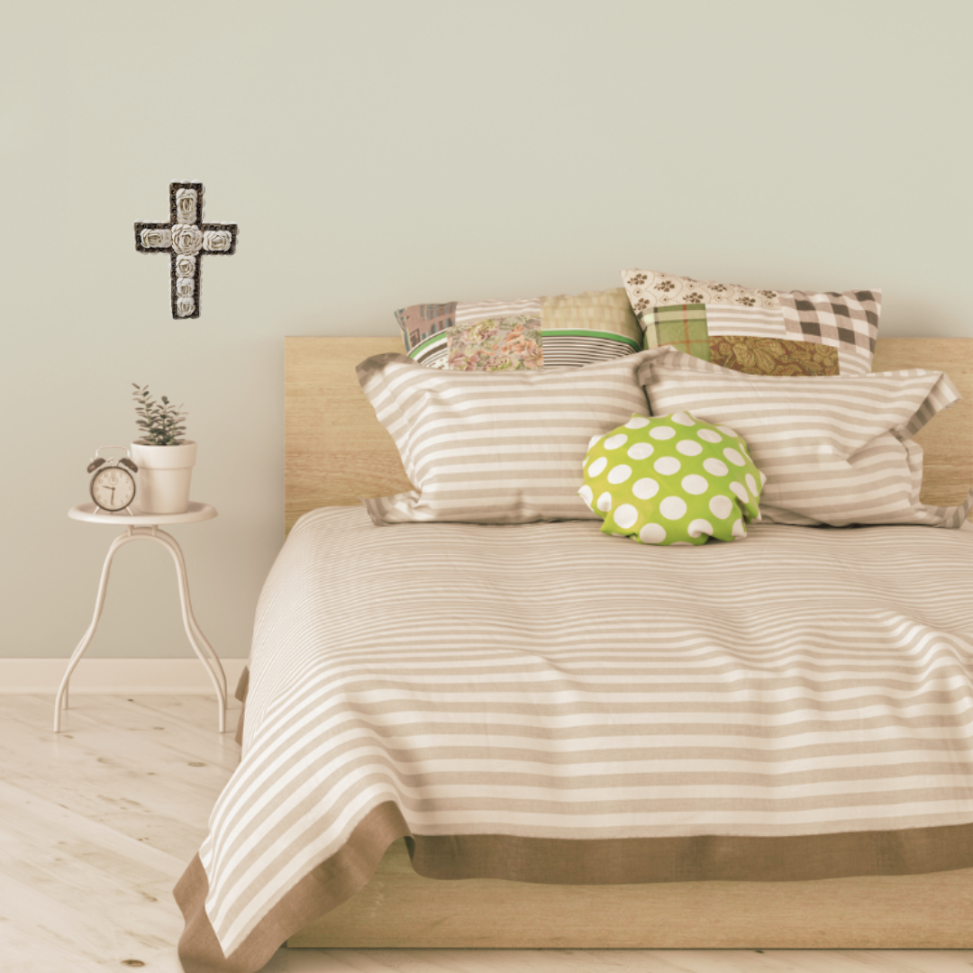 Bedroom with a bed featuring patterned pillows and a small side table with decor items.