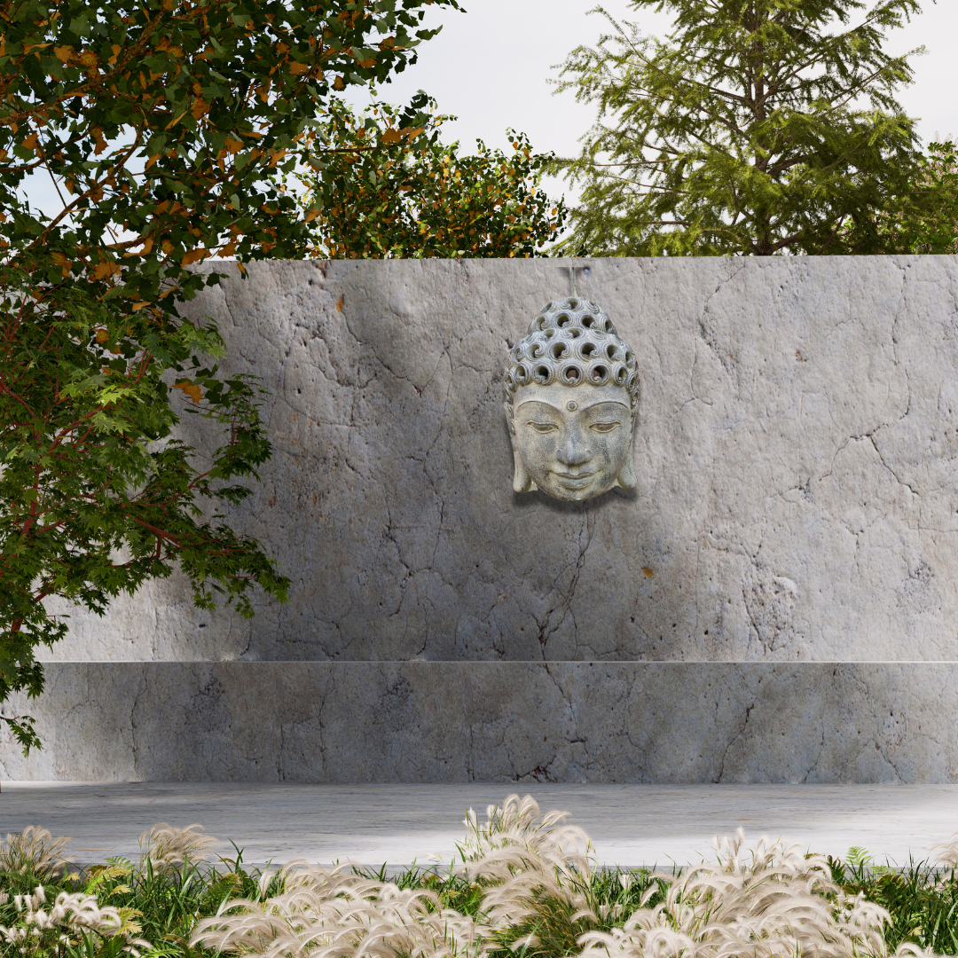 buddha head set on a concrete wall with a green garden 