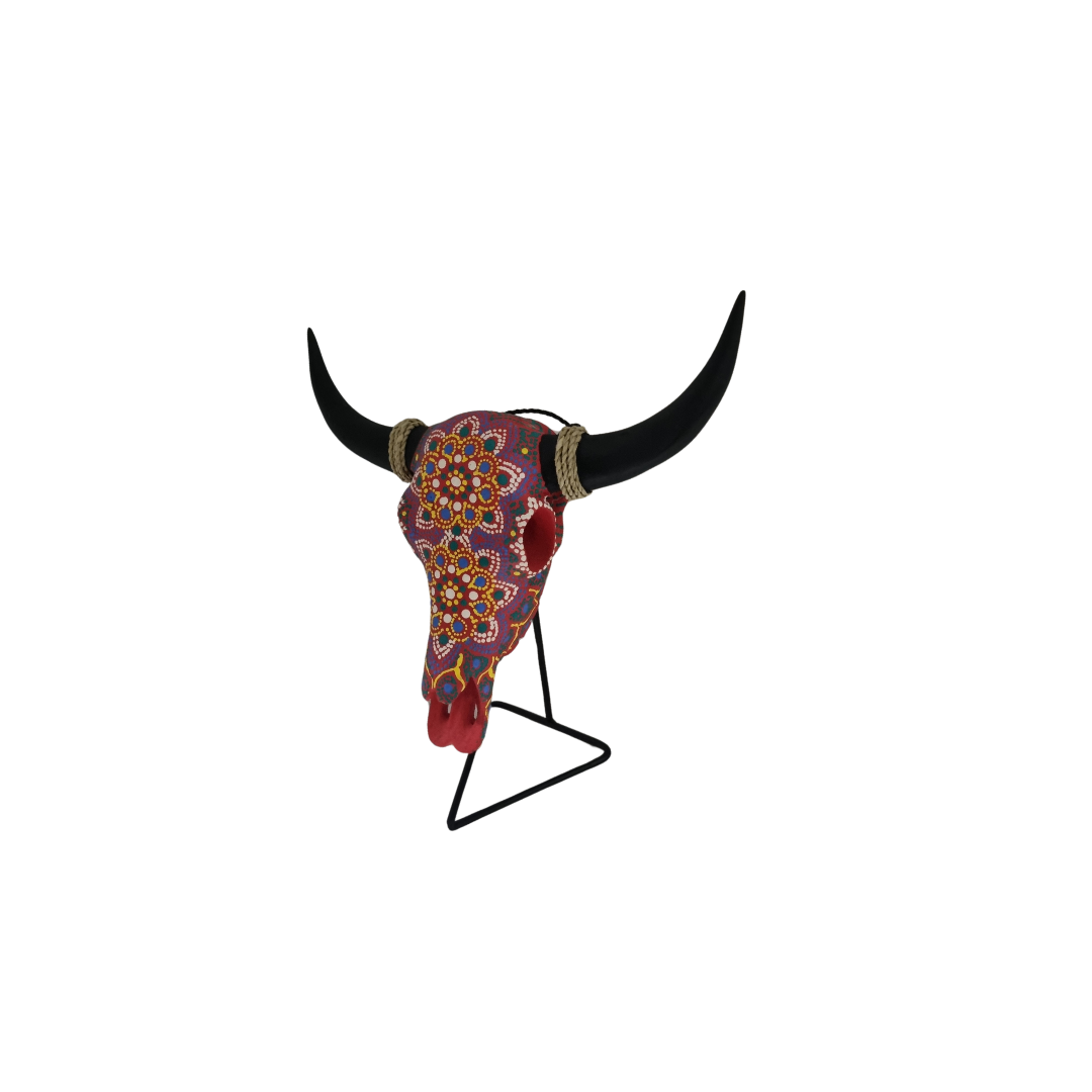 Vivid Tribal Bull Skull – hand-painted resin bull skull with vibrant purple and red dot mandala floral pattern, black horns with jute rope wraps and red eye sockets on black metal triangle stand, white background