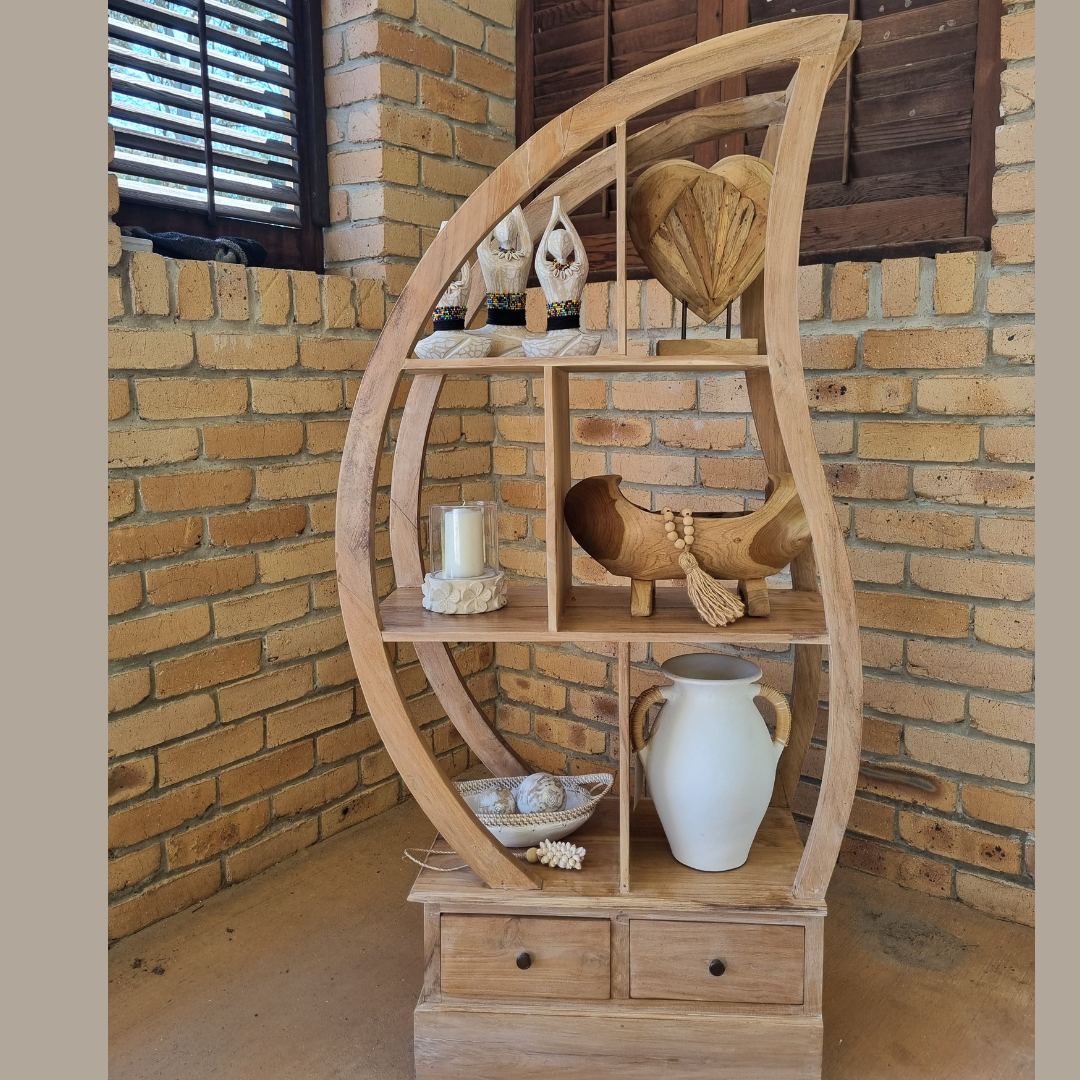Wooden circular shelf with decorative items against a brick wall.