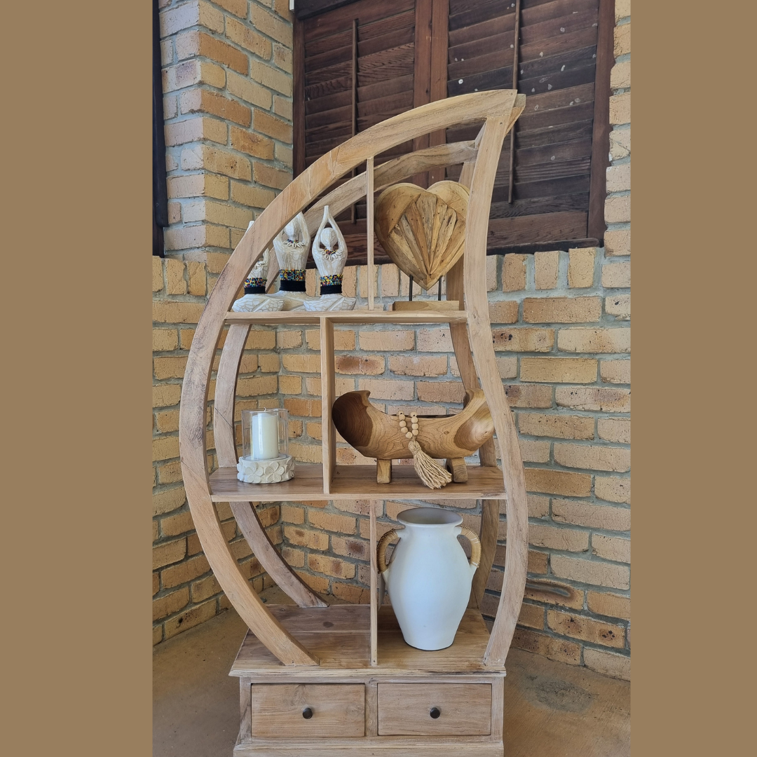 Wooden circular shelf with decorative items against a brick wall.