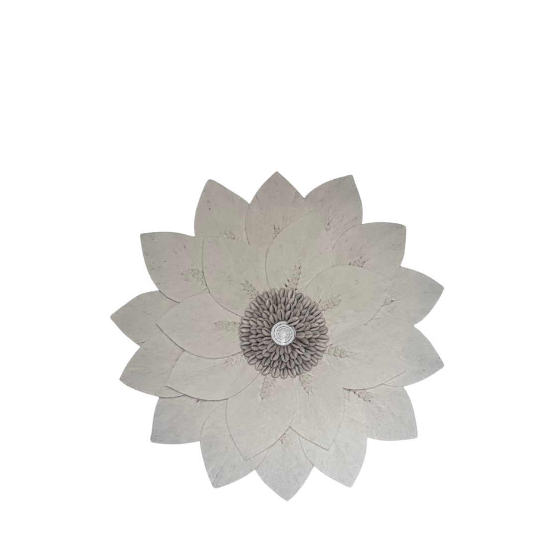 Macramé decorative wall piece shaped like a flower with a cowie shell centre detail against a white background, boho coastal wall décor.