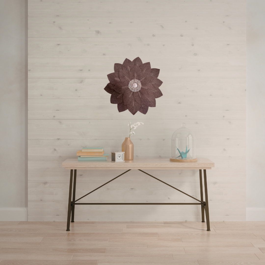 Decorative wall art above a wooden table with minimal decor in a room with light wood flooring and walls.
