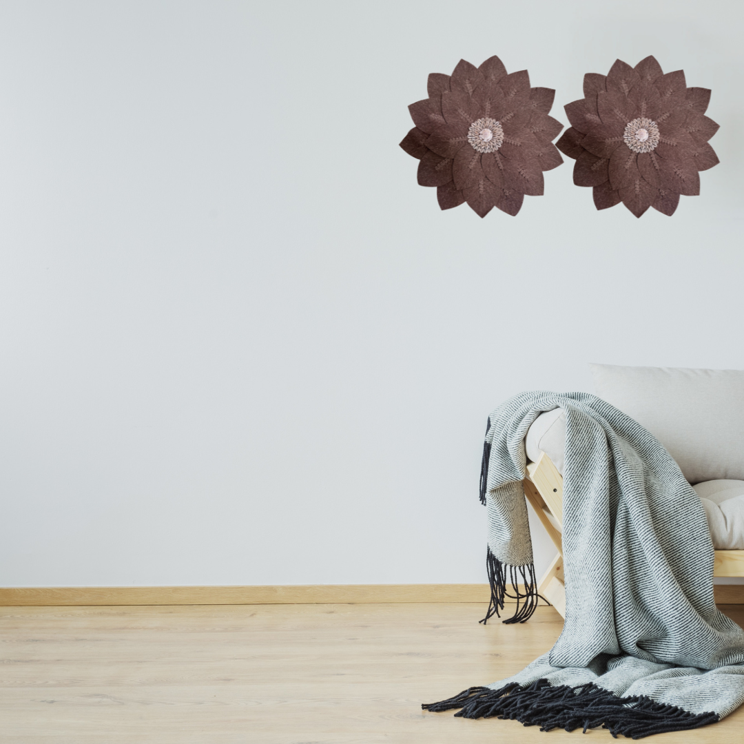 Two brown macramé floral leaf wall art pieces with shell centre detail styled above a timber sofa with grey throw – handcrafted boho coastal décor Australia