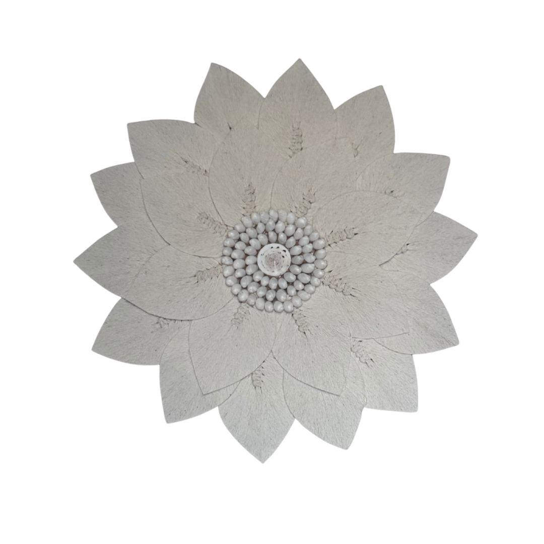 Macramé decorative wall piece shaped like a flower with a white shell centre detail against a white background, boho coastal wall décor.