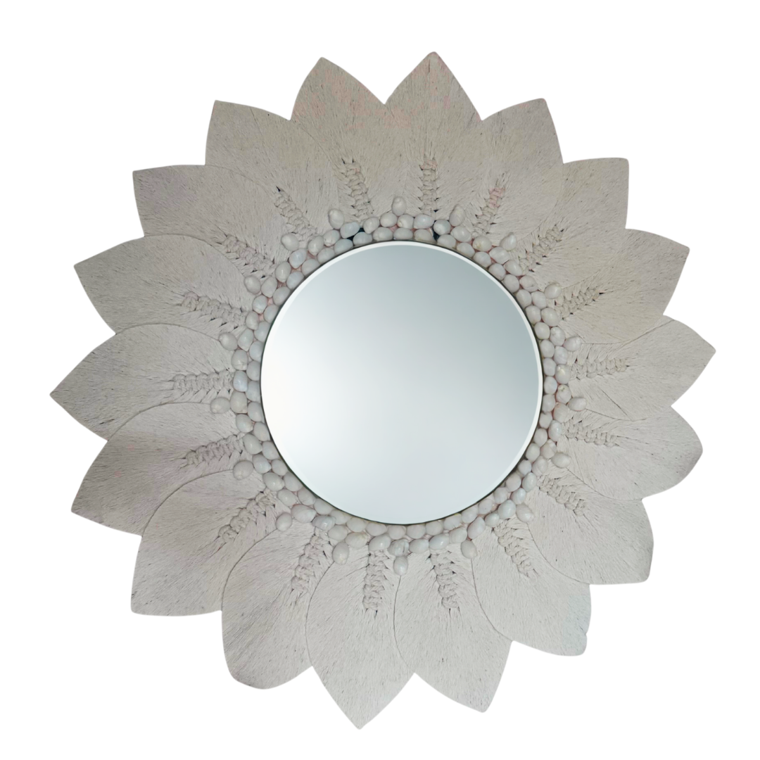 Macramé decorative wall mirror with a floral sunburst design on a white background, handcrafted boho coastal wall décor.