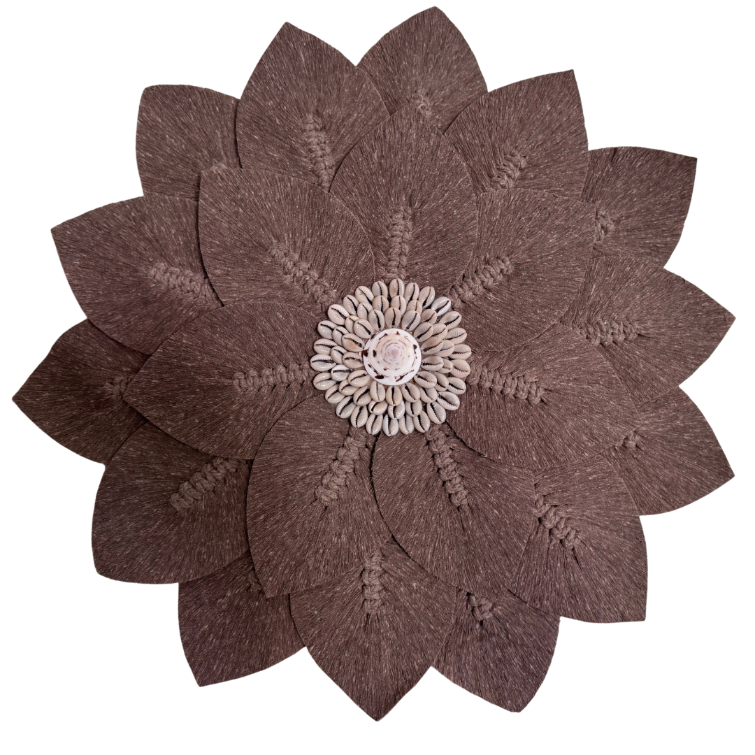 Brown flower-shaped macramé decorative wall piece with a centrer piece cowie shell  detail on a white background, boho coastal décor.