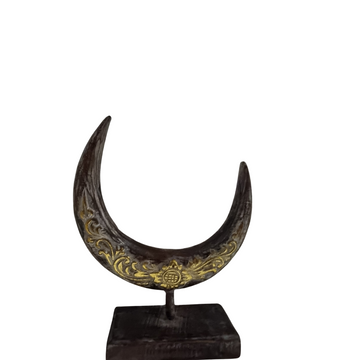 A crescent moon-shaped wooden decoration piece with a rustic brown wash finish, displayed on a stand.