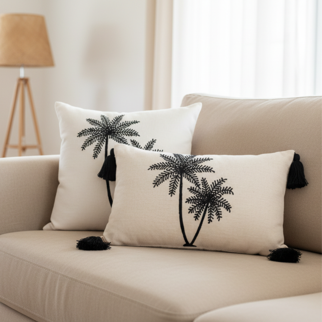 Square and lumbar palm tree embroidered cushion covers styled together on a linen sofa