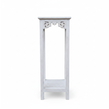 Distressed white wooden display stand with carved scroll apron detail, square top and open slatted lower shelf, shown against a plain white background | Azure Decor