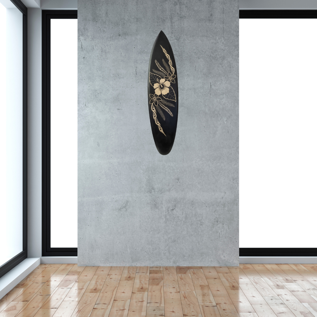 Hand-carved wooden surfboard wall art featuring a hibiscus flower in the midsection with flowing mural-style decorative art, displayed on a soft grey wall