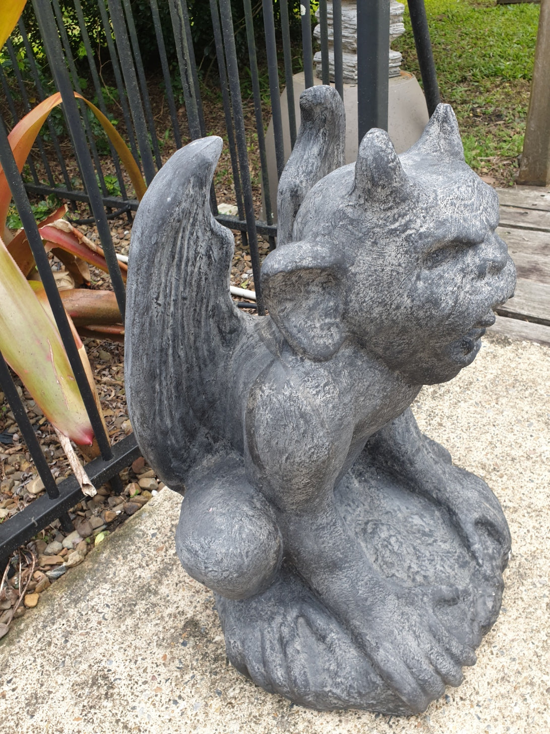 A rustic style gargoyle garden statue made from reinforced concrete and glass fiber, displayed in a natural outdoor setting.