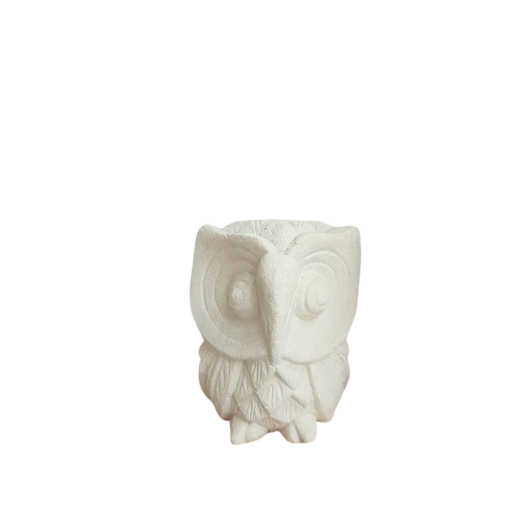 A limestone carving of owl in smallest, with a plain background.