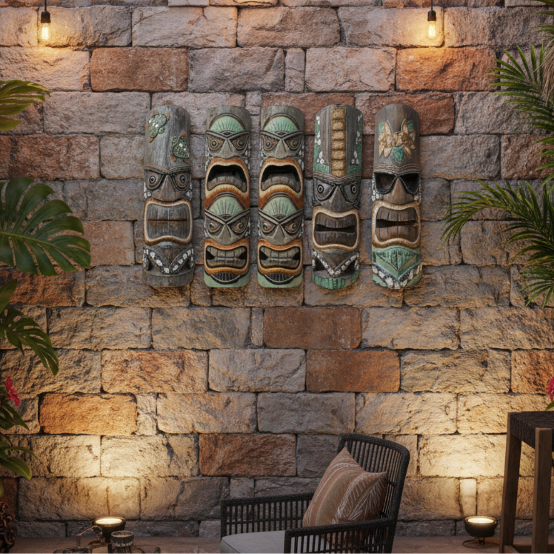 Five tiki masks on a stone wall with outdoor furniture and plants.
