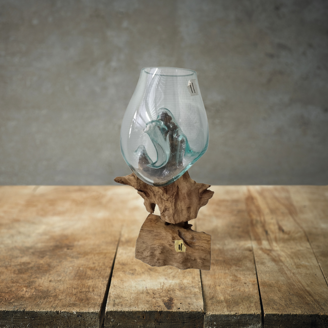Glass vase on a wooden stand against a gray background