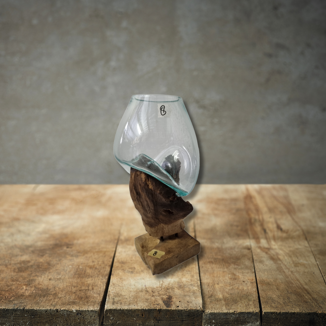 Glass container on a wooden stand with a textured wall background