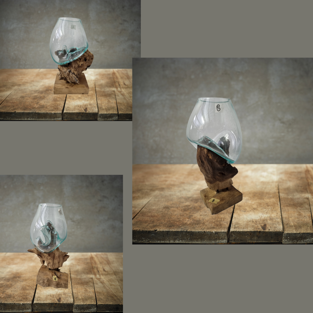 Decorative glass object on a wooden stand against a gray wall.