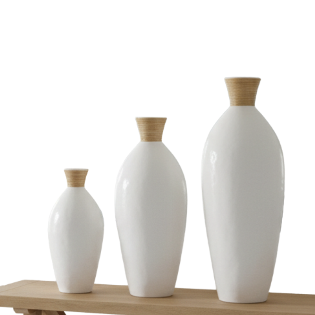 Three white vases with brown tops on a wooden surface against a white background