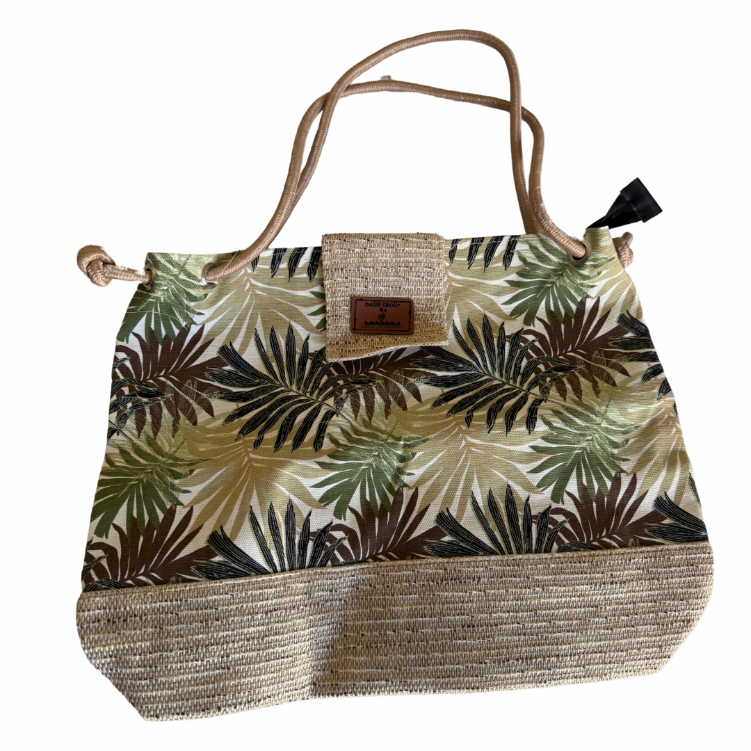 Tropical leaf patterned bag with woven base on a white background