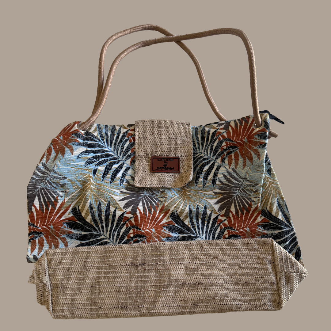 Tropical leaf patterned handbag with woven base on a beige background