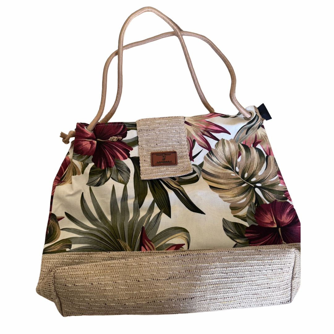 Tropical patterned handbag with woven base and handle on a white background