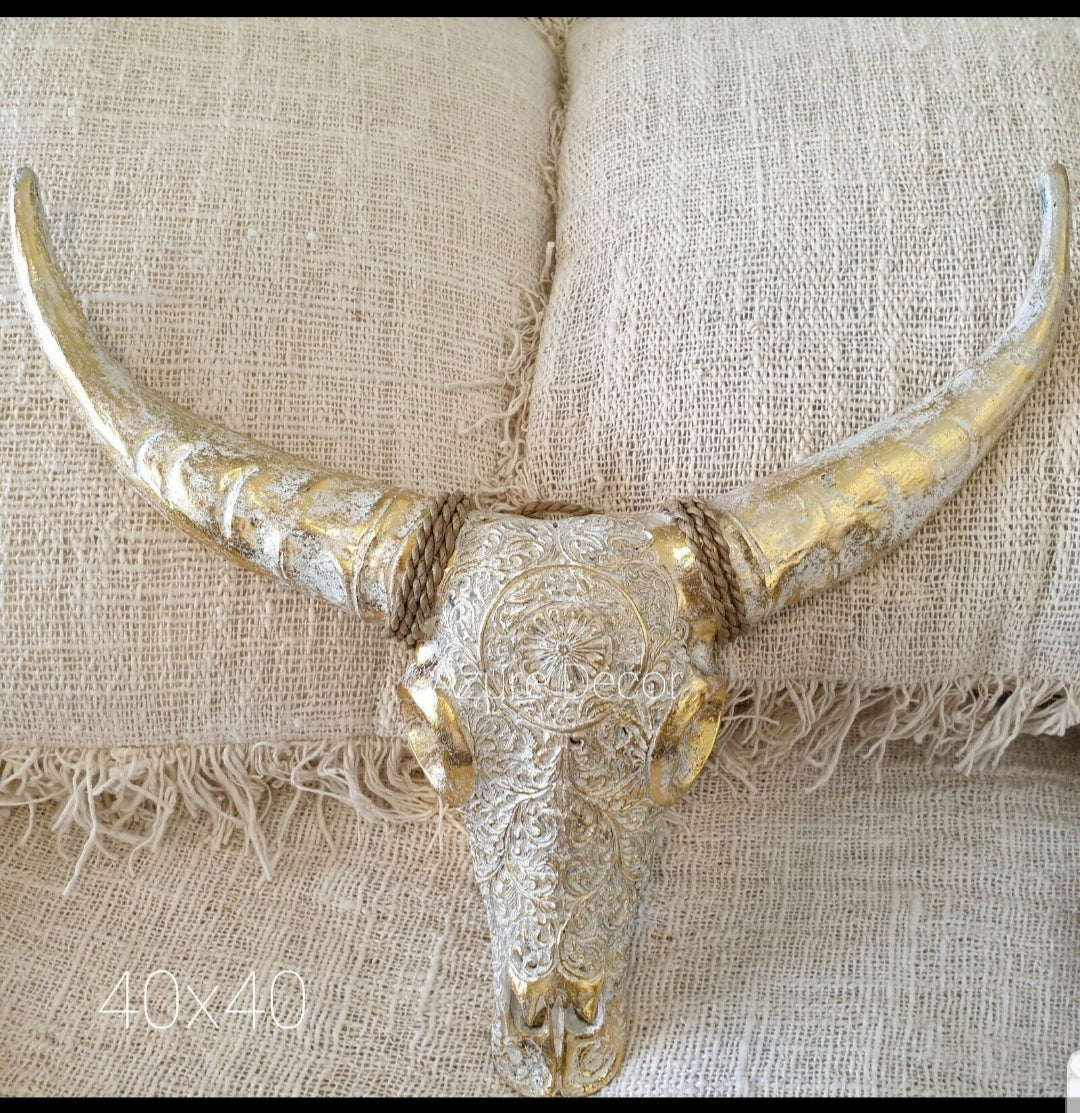Decorative gold bull skull on a textured beige fabric background
